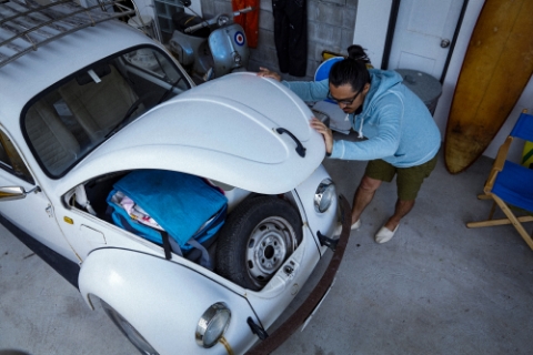 ガレージでボンネットを閉める男性