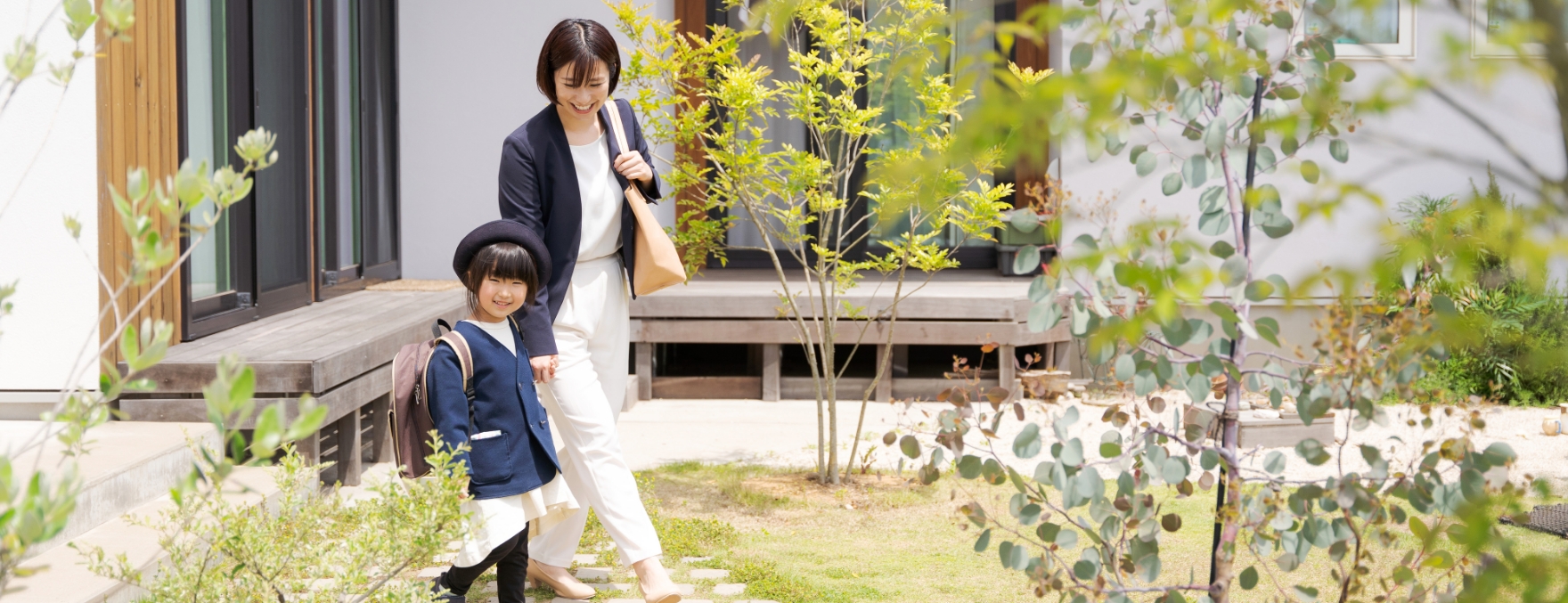 庭にある木を見ている女の子とお母さんの写真
